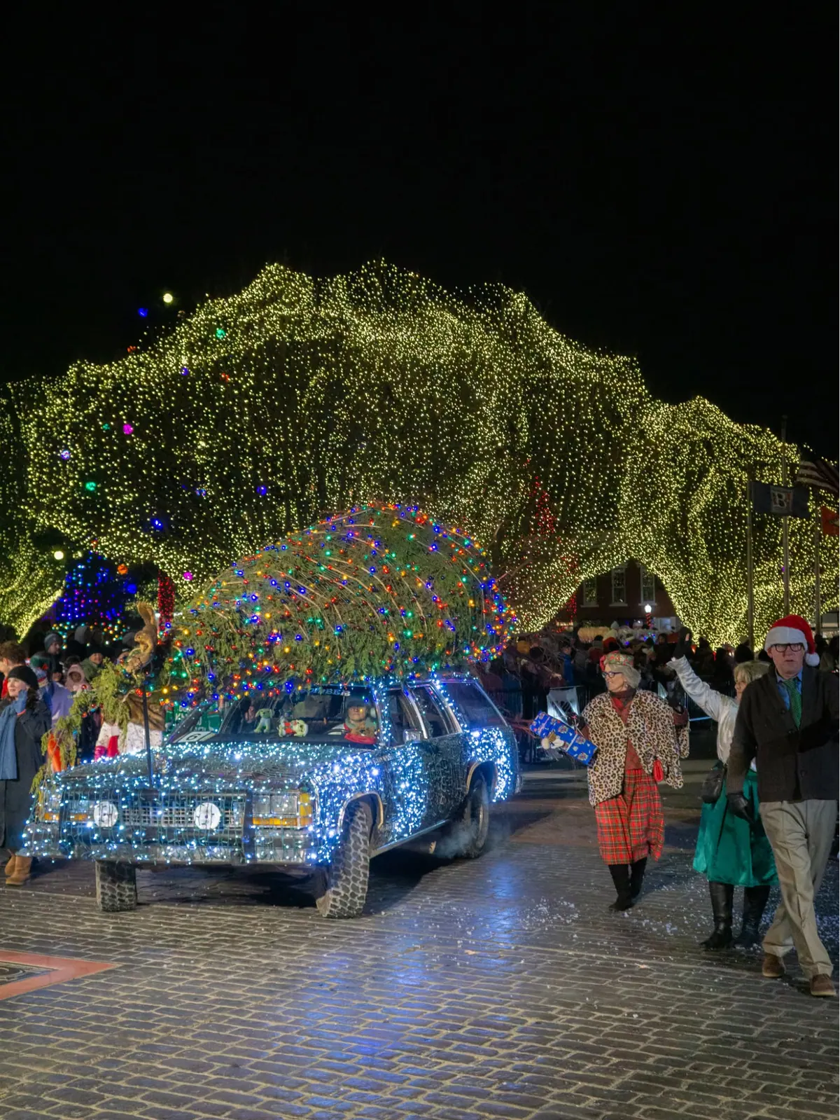 Light-covered truck rolling under a canopy of Christmas lights on the Bentonville Square