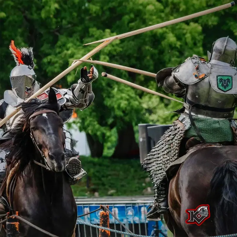 Two armored knights on horseback jousting with lances